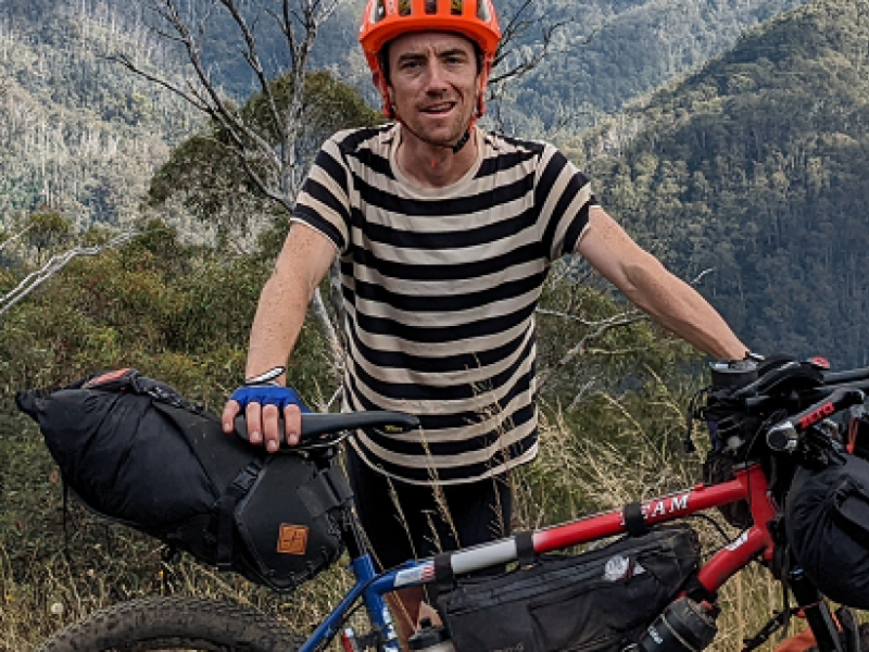man standing behind his bicycle 