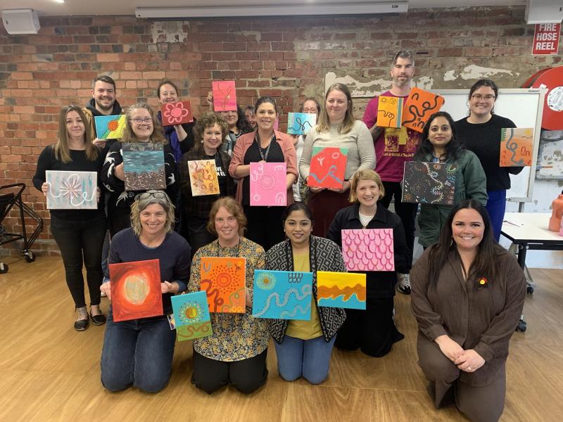 Group holding up artwork