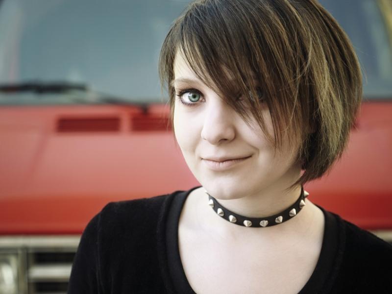 Young woman wearing a black top and a studded necklace