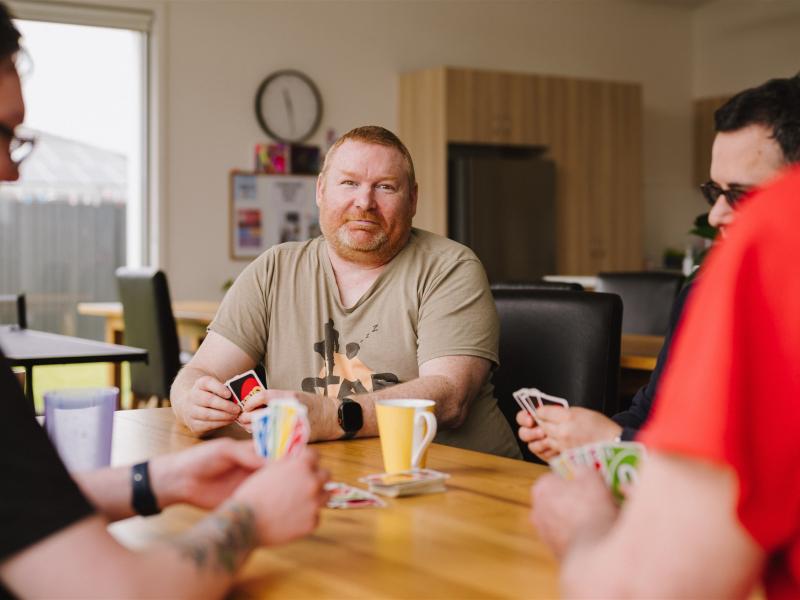Haven resident Darren plays a card game with other residents.