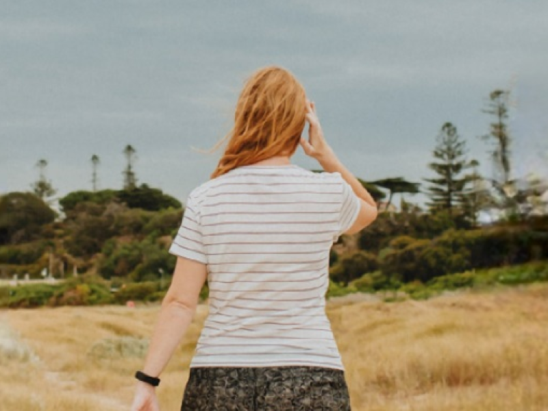 Woman walking on a beach with back to camera