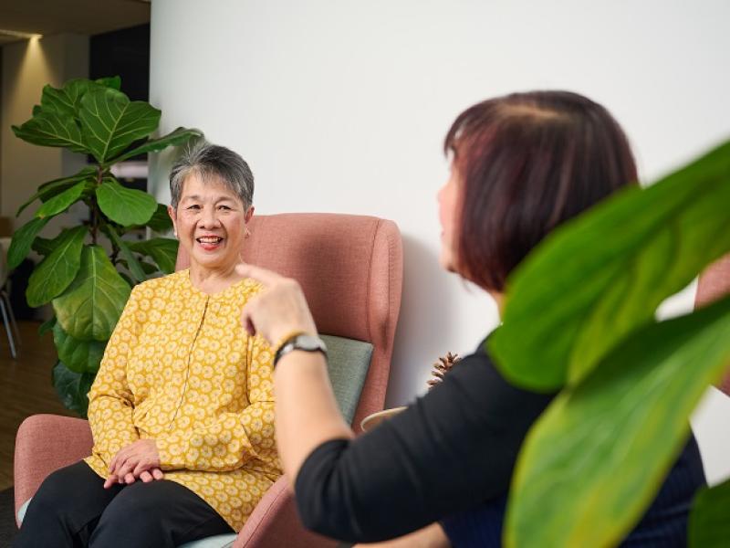 Two women chatting in comfortable chairs inside