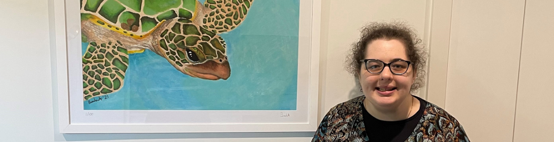 young woman standing next to art work